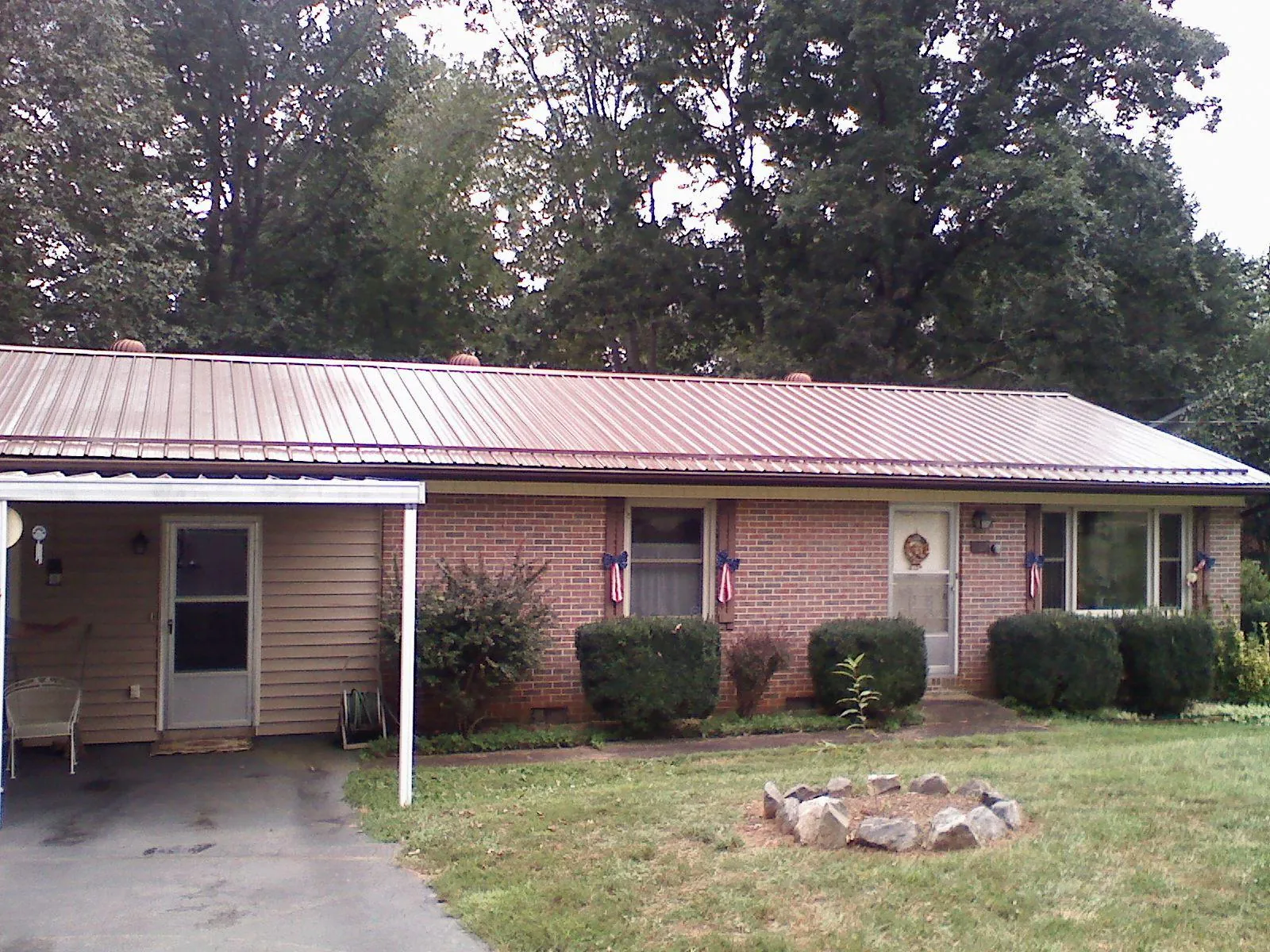 Bronze metal roof and carport on a brick ranch home — Roof Repair work by our crew in West Point
